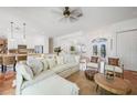 Open concept living room with white sectional sofa, tile floors, and view into the kitchen at 4658 Arlington Dr, Placida, FL 33946