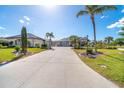 Stately single-story home featuring a long concrete driveway, well-kept lawn, and mature palm trees at 646 Boundary Blvd, Rotonda West, FL 33947