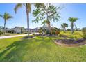 Tropical landscaping surrounds this home with palm trees and lush green lawn at 646 Boundary Blvd, Rotonda West, FL 33947