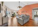 Spacious living room with hardwood floors, gray sofas, and a view of the backyard at 9266 Carnation Ave, Englewood, FL 34224