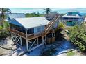 Elevated beach house with screened porch, wood decks, and stairway to rooftop terrace at 9526 Jolly Roger Trl, Placida, FL 33946