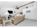 Spacious living room with beige sofas, a coffee table, and a ceiling fan at 119 Bunker Rd, Rotonda West, FL 33947