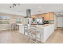 Modern kitchen with white cabinets, stainless steel appliances, and an island at 1493 Janet Pl, Englewood, FL 34223