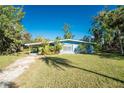Light blue single story home with carport and lush landscaping at 1770 Hudson St, Englewood, FL 34223