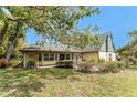 Inviting home with a lovely front porch, mature landscaping, and a welcoming entrance, nestled under a shady tree at 1828 Whispering Pines Cir, Englewood, FL 34223