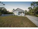 Newly built home at dusk, featuring gray siding and a white porch at 18302 Gypsy Ave, Port Charlotte, FL 33954