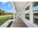 Inviting front porch with wood flooring and white columns at 18389 Dakota Ave, Port Charlotte, FL 33954