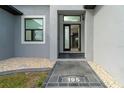 Front door entry with stone walkway and landscaping at 195 W Pine Valley Ln, Rotonda West, FL 33947