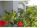 Close up of the home's exterior highlighting well-manicured landscaping and a charming arched window at 328 Baytree Dr, Rotonda West, FL 33947