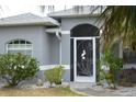 Charming front door with decorative screen and well-maintained landscaping, creating a welcoming entrance at 328 Baytree Dr, Rotonda West, FL 33947