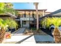 Front view of condo with walkway, parking and tropical plants at 502 Pine Hollow Cir # 502, Englewood, FL 34223