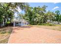 Brick driveway leads to a charming house nestled in lush greenery at 7147 Lago St, Sarasota, FL 34241
