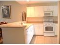 White kitchen with breakfast bar and appliances at 8100 Memory Ln # 207, Rotonda West, FL 33947