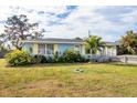 Charming light blue home with a well-manicured lawn and garden at 857 E 6Th St, Englewood, FL 34223