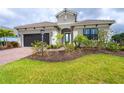 Two-story home with gray exterior, brick driveway and landscaping at 10958 Trevino St, Englewood, FL 34223