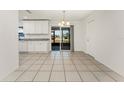 Bright dining area with white cabinets, granite countertops, and sliding glass doors to the outside at 7330 Regina Dr, Englewood, FL 34224