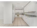 Modern kitchen featuring white cabinets, granite countertops, and stainless steel appliances at 7330 Regina Dr, Englewood, FL 34224