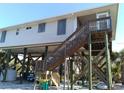 Elevated coastal home with storm shutters and wooden deck, offering serene views and protection from the elements at 91 Gasparilla Way, Placida, FL 33946