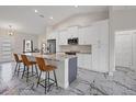Spacious kitchen features granite counters, stainless appliances, gray island, and marble flooring at 11247 Euler Ave, Englewood, FL 34224