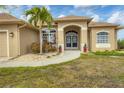Inviting front entrance with double doors, decorative plants, and arched window details at 116 Hercules Dr, Rotonda West, FL 33947