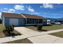 Cozy single-Gathering home featuring an attached garage, screened porch, and a neatly landscaped front yard at 13537 Bennett Dr, Port Charlotte, FL 33981