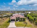 Stunning waterfront home featuring lush landscaping, mature palms and a private dock at 14448 Edna Cir, Port Charlotte, FL 33981