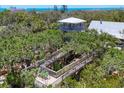 Unique home exterior featuring elevated walkways and a gazebo nestled in lush greenery at 7475 Manasota Key Rd, Englewood, FL 34223