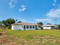 Back view of home featuring a sun room and large lawn at 914 E 2Nd St, Englewood, FL 34223