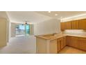 Open-concept living room features a well-equipped kitchen and sliding glass doors to the balcony at 10045 Links Ln # 203, Rotonda West, FL 33947