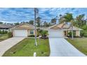 Charming single-story home featuring a two-car garage and meticulously landscaped front yard at 215 Australian Dr, Rotonda West, FL 33947