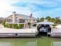 Beautiful waterfront home featuring a boat lift, dock, and landscaped yard with palm trees at 2805 N Beach Rd # B, Englewood, FL 34223