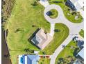 Bird's eye view of home with lush green yard, mature trees, pool, and circular driveway at 3522 Fox Ter, Port Charlotte, FL 33981