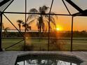 Tranquil sunset view from the screened-in pool area, showcasing the serene outdoor living space at 3522 Fox Ter, Port Charlotte, FL 33981