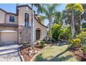 Charming home featuring a stone accent wall, arched entryway, and well-manicured landscaping at 117 Cable Dr, Rotonda West, FL 33947