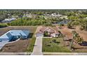 Expansive aerial view showcasing the single-story home, its manicured lawn, nearby lakes, and lush green trees at 411 Boundary Blvd, Rotonda West, FL 33947