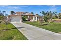 Inviting single-story home featuring a well-maintained lawn, mature landscaping and a long driveway leading to an attached garage at 411 Boundary Blvd, Rotonda West, FL 33947