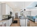 Modern kitchen featuring white cabinetry, black countertops, and stainless steel appliances at 497 Rotonda Cir, Rotonda West, FL 33947