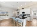 Bright kitchen featuring a large island with bar seating, stainless steel appliances, and wood-look tile floors at 497 Rotonda Cir, Rotonda West, FL 33947