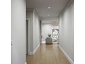 Inviting hallway with wood flooring, leading into a bright and airy living room with neutral decor at 5344 Hornbuckle Blvd, North Port, FL 34291