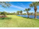 Expansive backyard with a waterfront view and mature palm trees at 891 Harmony Ln, Englewood, FL 34223