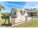 Side view of house with patio, fence, and flower boxes beneath windows at 891 Harmony Ln, Englewood, FL 34223