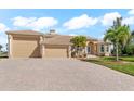 Lovely tan single story home with a tile roof, arched entry, and attached garage on a sunny day at 10544 Poughkeepsie Cir, Port Charlotte, FL 33981