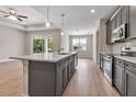 Modern kitchen with a center island, gray cabinets, pendant lighting and stainless steel appliances at 2814 Vogler Ln, North Port, FL 34286