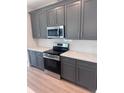 Modern kitchen with gray cabinets, stainless steel appliances, and white countertops at 2814 Vogler Ln, North Port, FL 34286