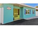 Close up of front entrance showing bright blue home exterior with lime green door and trim at 539 Shore Rd, Nokomis, FL 34275