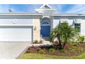 Charming home featuring a lush lawn, beautiful landscaping, and a delightful blue front door at 8768 Conch Ave, Placida, FL 33946