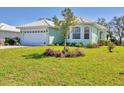 Inviting single-story home with a lush green lawn and mature landscaping at 109 Westwind Dr, Placida, FL 33946