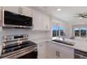 Beautiful kitchen featuring stainless steel appliances, white cabinets, and a scenic water view at 11000 Placida Rd # 301, Placida, FL 33946
