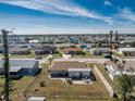 Aerial view of a fenced-in backyard with patio set, surrounded by neighborhood homes under a blue sky at 13532 Romford Ave, Port Charlotte, FL 33981