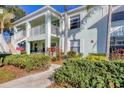 Two-story condo with private balcony and lush landscaping along the walkway to the building at 5725 Greenwood Ave # 8101, North Port, FL 34287